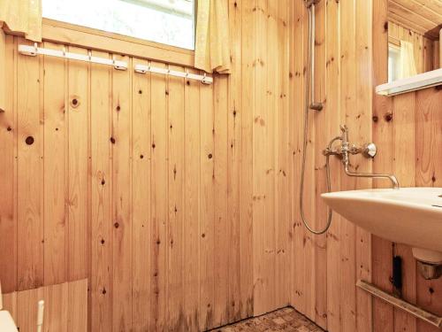 ein Badezimmer mit Holzwänden und einem Waschbecken in der Unterkunft Holiday home Stege XVII in Stege