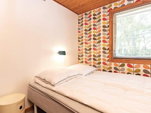 ein kleines Schlafzimmer mit einem Bett und einem Fenster in der Unterkunft Holiday home Stege XVII in Stege