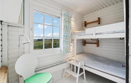ein kleines Zimmer mit einem Etagenbett und einem Stuhl in der Unterkunft Cozy Home In Hvide Sande With Kitchen in Hvide Sande