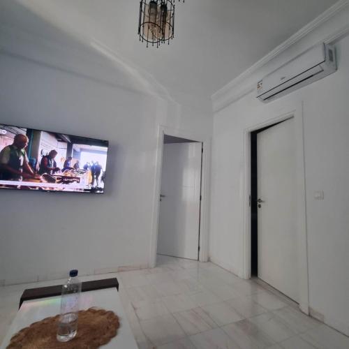 a white room with a tv on a wall at City View, Ennasr Spacious s2 Apartment in Ariana