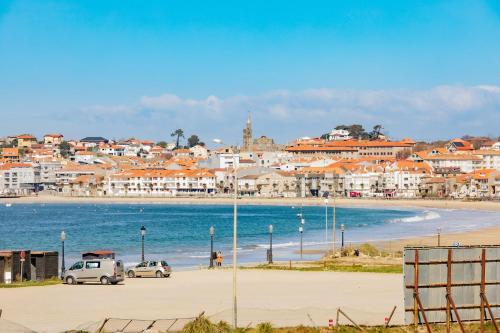 a view of a beach with buildings and cars at Apartamentos Villa Zoila Nigrán in Nigrán