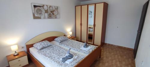 - une chambre avec un lit et un miroir dans l'établissement Valerie Apartman, à Drvenik