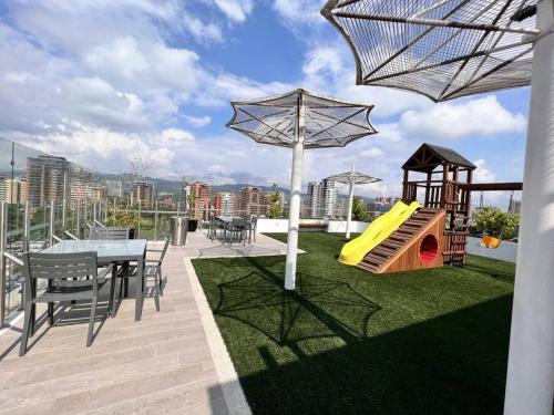 a rooftop patio with a table and a playground at Narama Luxury near to the airport in Guatemala