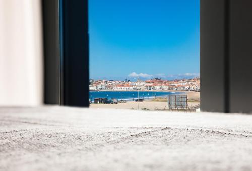 a view of a beach from a window at Apartamentos Villa Zoila Nigrán in Nigrán