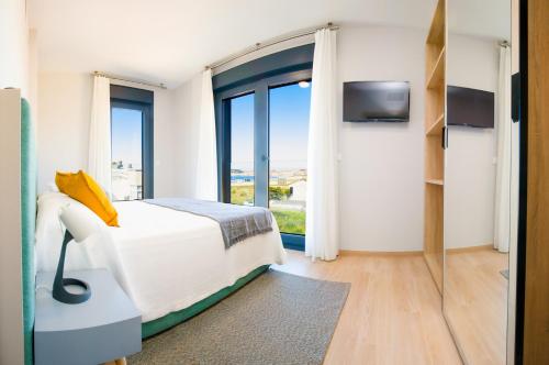 a bedroom with a bed and a large window at Apartamentos Villa Zoila Nigrán in Nigrán