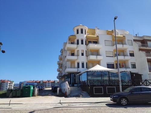 un bâtiment avec une voiture garée devant lui dans l'établissement Apartment by the beach! With large balcony!, à São Martinho do Porto