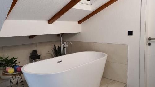a white bath tub in a bathroom with a ceiling at Apartmani Gandi in Bihać