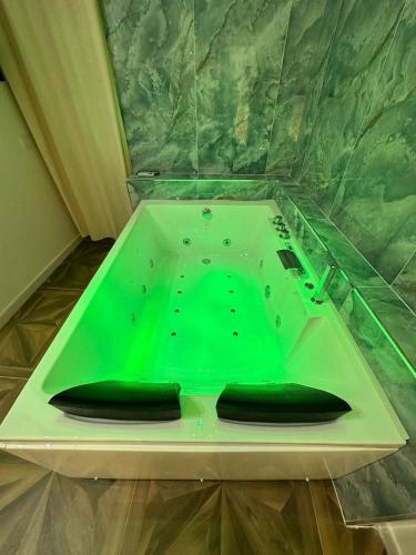 a green bath tub with two black objects in it at San Ferdinando suite room in Naples