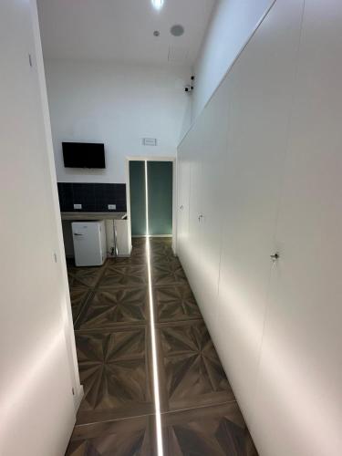 a hallway with white walls and a wooden floor at San Ferdinando suite room in Naples