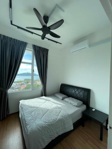 a bedroom with a bed and a ceiling fan at Inns Homestay in Sandakan