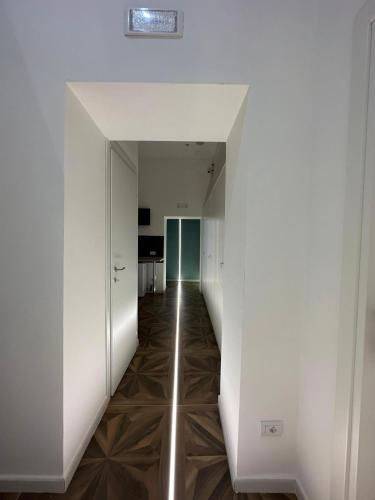 an empty hallway with white walls and a hallway with a hallway at San Ferdinando suite room in Naples