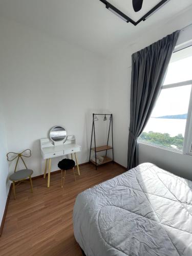 a bedroom with a bed and a desk and a window at Inns Homestay in Sandakan