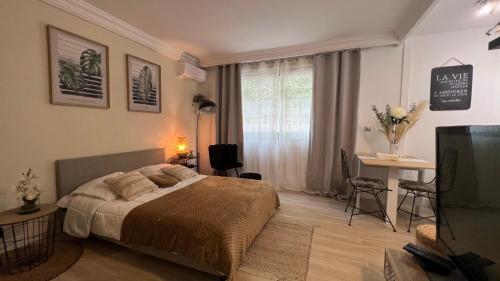 une chambre avec un lit, un bureau et une fenêtre dans l'établissement LE MIRAMAR Nice - Clim, Parking, Wifi et piscine, à Nice