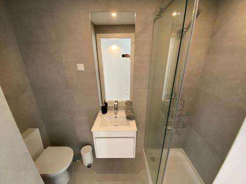 a bathroom with a toilet and a sink and a shower at Carcavelos Beach Walking distance room in Oeiras
