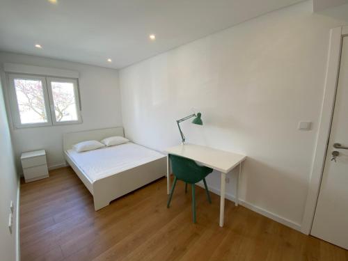 a bedroom with a bed and a desk and a window at Carcavelos Beach Walking distance room in Oeiras