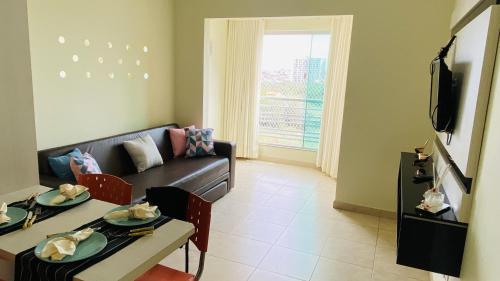 a living room with a couch and a table at Apartamento Thermas in Caldas Novas
