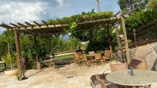 a wooden pergola with tables and chairs on a patio at Apartamento Thermas in Caldas Novas