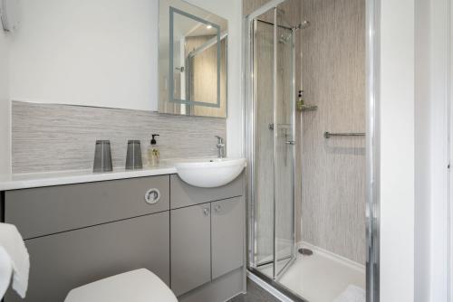 a white bathroom with a sink and a shower at The Rowan Tree Country Hotel in Aviemore