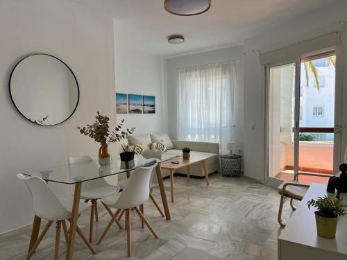 una sala de estar blanca con mesa y sillas en costa ballena elite, en Costa Ballena