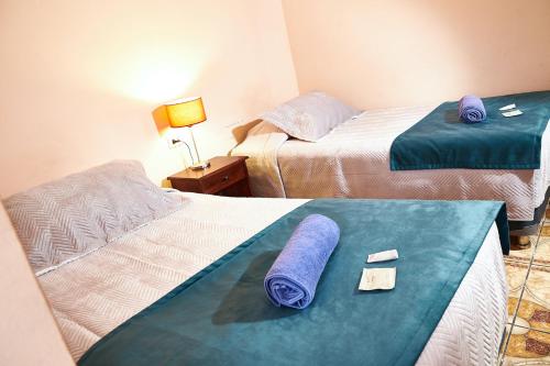 Habitación de hotel con 2 camas y toallas. en Hotel Pulmahue, en Copiapó