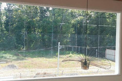 a window with a view of a fence at CR Caribbean Blue House - Modern style 100 WiFi in Cahuita