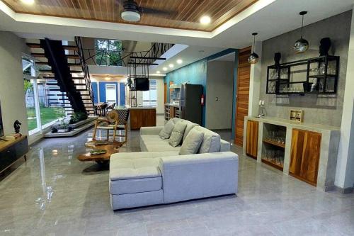 a living room with a white couch and a kitchen at CR Caribbean Blue House - Modern style 100 WiFi in Cahuita