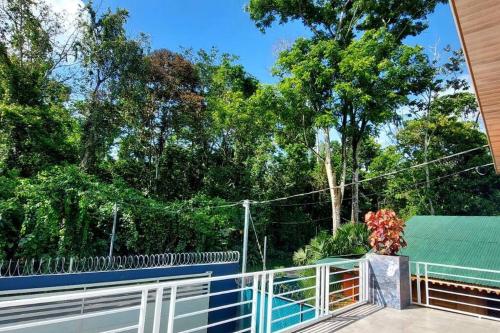 a porch with a fence and trees in the background at CR Caribbean Blue House - Modern style 100 WiFi in Cahuita