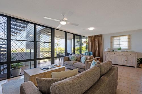 a living room with a couch and a table at Beachfront Apt with rooftop spa across from Marcoola Beach in Marcoola