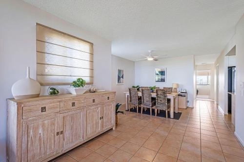 a living room with a table and a dining room at Beachfront Apt with rooftop spa across from Marcoola Beach in Marcoola