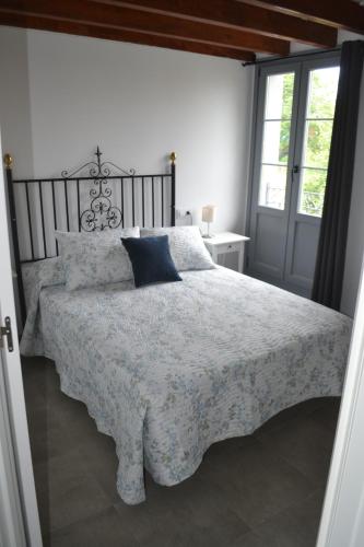 een slaapkamer met een bed met een blauw kussen erop bij El Molino 3 in Muros de Nalón