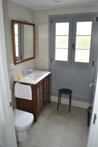 een badkamer met een wastafel, een toilet en een spiegel bij El Molino 3 in Muros de Nalón