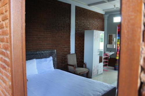 a bedroom with a bed and a brick wall at Georium Dunia in Prambanan