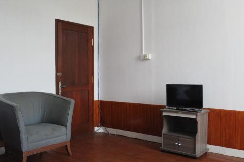 a living room with a chair and a television at Georium Dunia in Prambanan