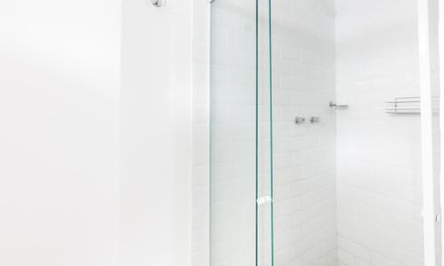 um chuveiro com uma porta de vidro na casa de banho em Tabas - Lindíssimo apê 3 quartos na Lagoa - LG0006 no Rio de Janeiro