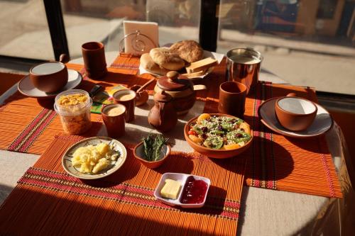 a table with plates of food on top at The Little House ApartHotel in Uyuni