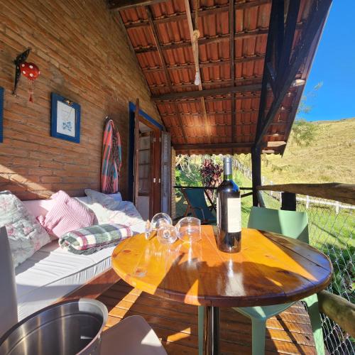a wooden table with wine glasses on a patio at Pousada Vale Monte Azul in Santo Antônio do Pinhal