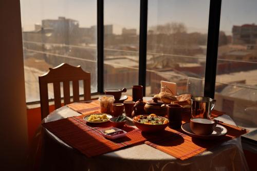 una mesa con comida en ella con una ventana en The Little House ApartHotel, en Uyuni