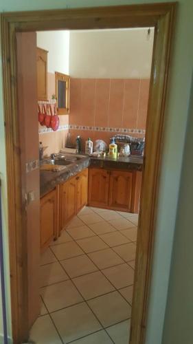 a kitchen with wooden cabinets and a tile floor at Apparemment mohammedia in Mohammedia