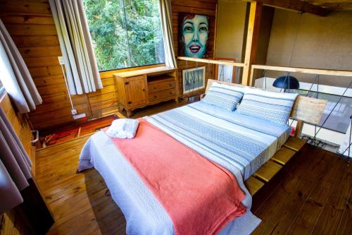 a bedroom with a bed with a face painted on the wall at Casas Temporada Aldeia Niura Opy in Florianópolis