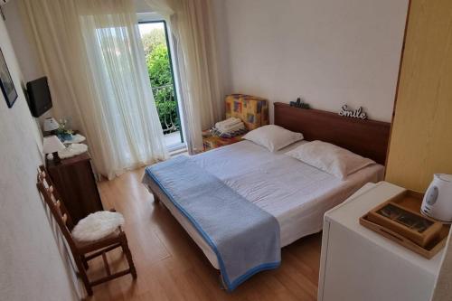 Un dormitorio con una cama grande y una ventana en Apartments and rooms with parking space Supetar, Brac - 5658 en Supetar