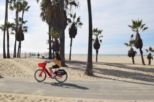 a girl riding a bike on the beach at Villa by the Ocean in Venice Beach in Los Angeles