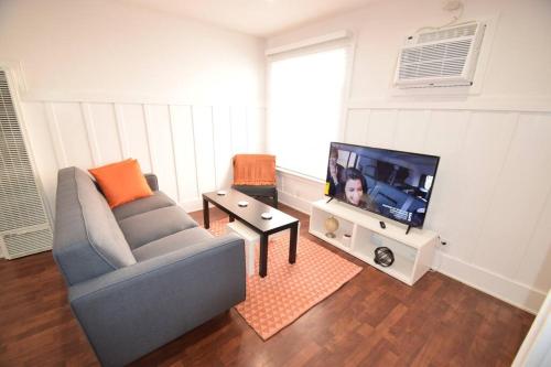 a living room with a couch and a flat screen tv at Villa by the Ocean in Venice Beach in Los Angeles