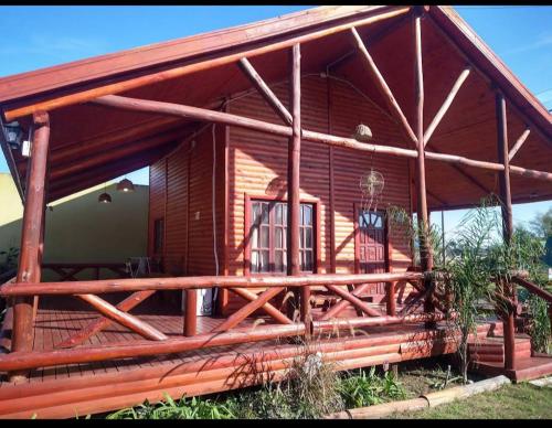 a large wooden cabin with a large porch at Cabaña La Justina in San José