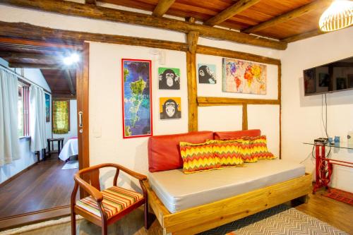 a living room with a bed and a chair at Casas Temporada Aldeia Niura Opy in Florianópolis