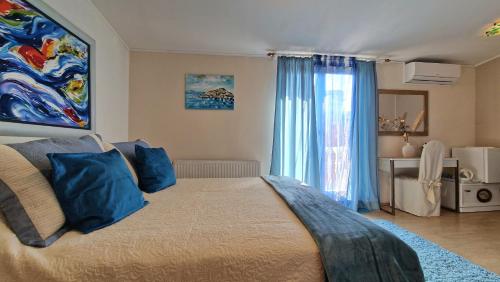 a bedroom with a large bed with blue pillows at Guest House Villa Ines - Annex in Zadar