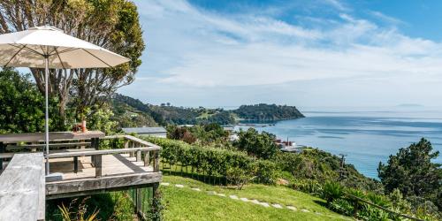 a picnic table with an umbrella overlooking the ocean at The View - Coast & Country in Onetangi