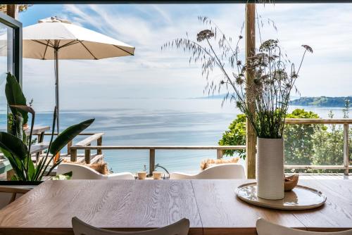 a table with a vase on it with a view of the ocean at The View - Coast & Country in Onetangi