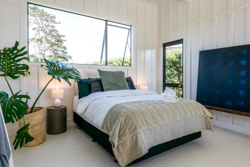 a bedroom with a bed and a large window at The View - Coast & Country in Onetangi