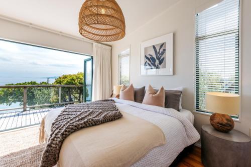 a bedroom with a bed and a large window at The View - Coast & Country in Onetangi