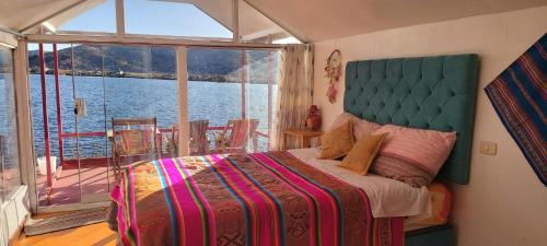 a bedroom with a bed and a view of the water at Uros TITICACA home lodge in Puno